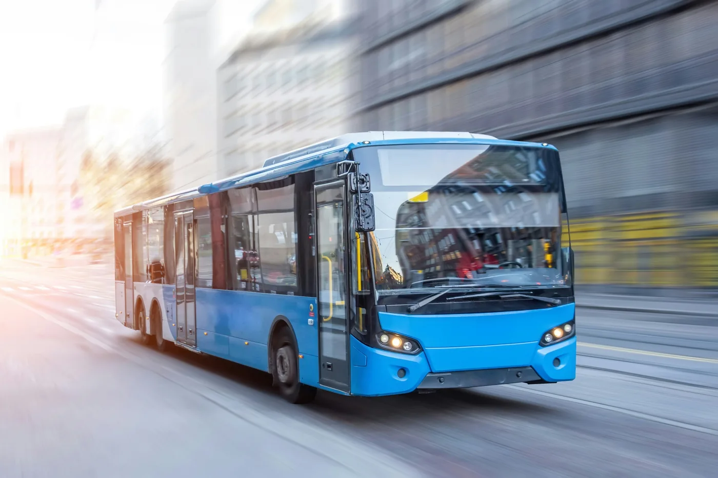 A blue city bus driving along a street