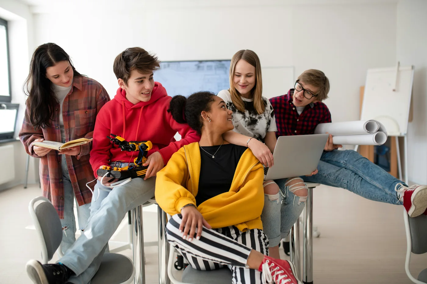 Young people collaborating around a laptop