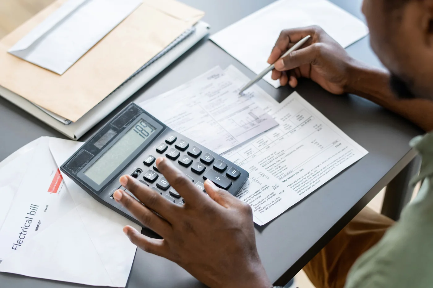 A person reviewing paperwork with a calculator