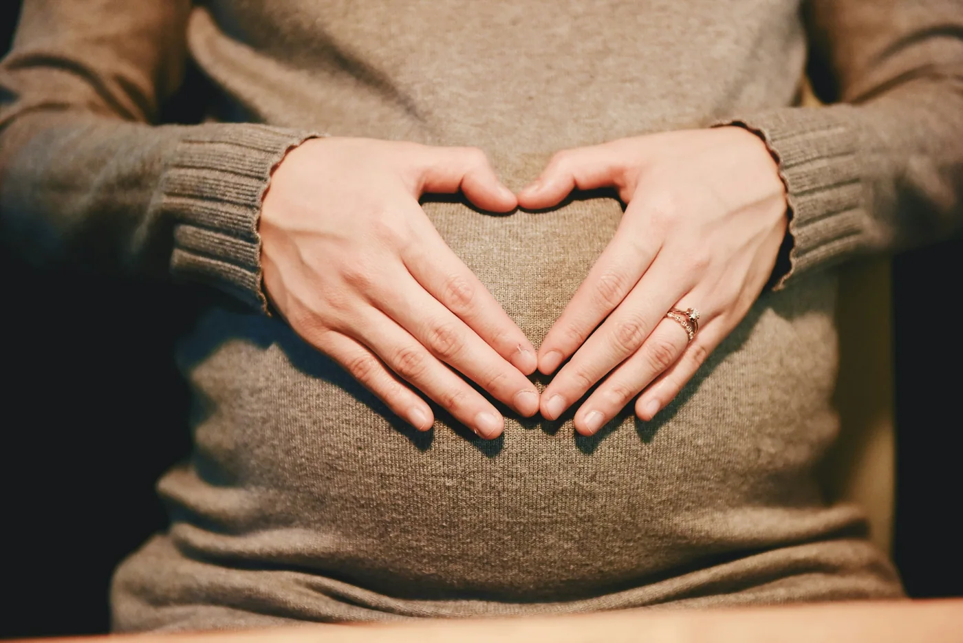 A person resting their hands over their belly
